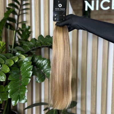 a hair bulk held by a hand in a black glove