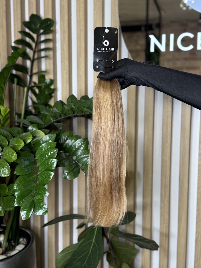 a hair bulk held by a hand in a black glove