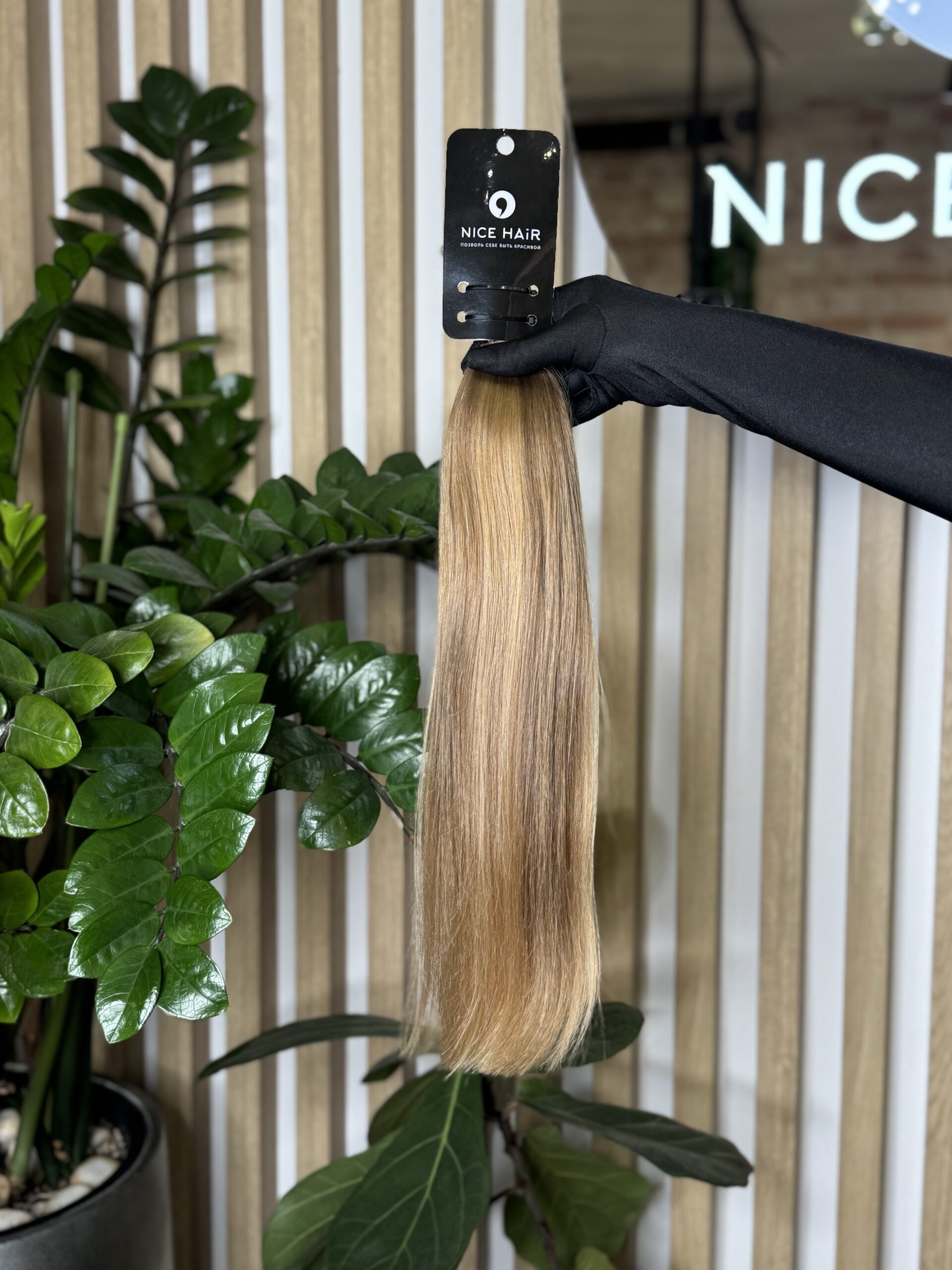 a hair bulk held by a hand in a black glove